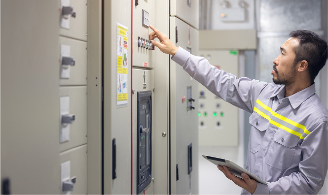 An Albireo Energy employee pointing to an Electrical Power Monitoring System.