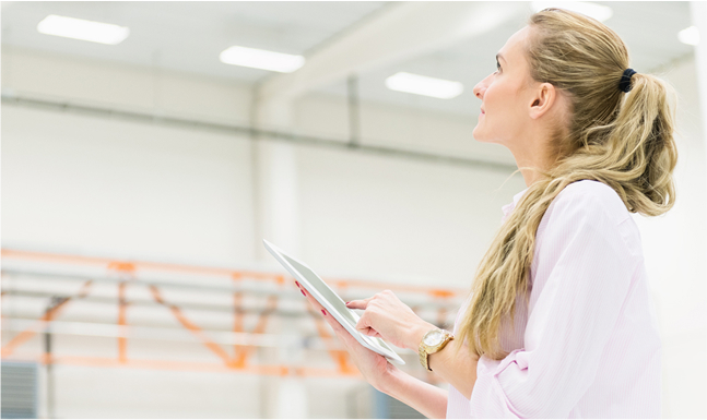 A woman looking at the lighting in a room.